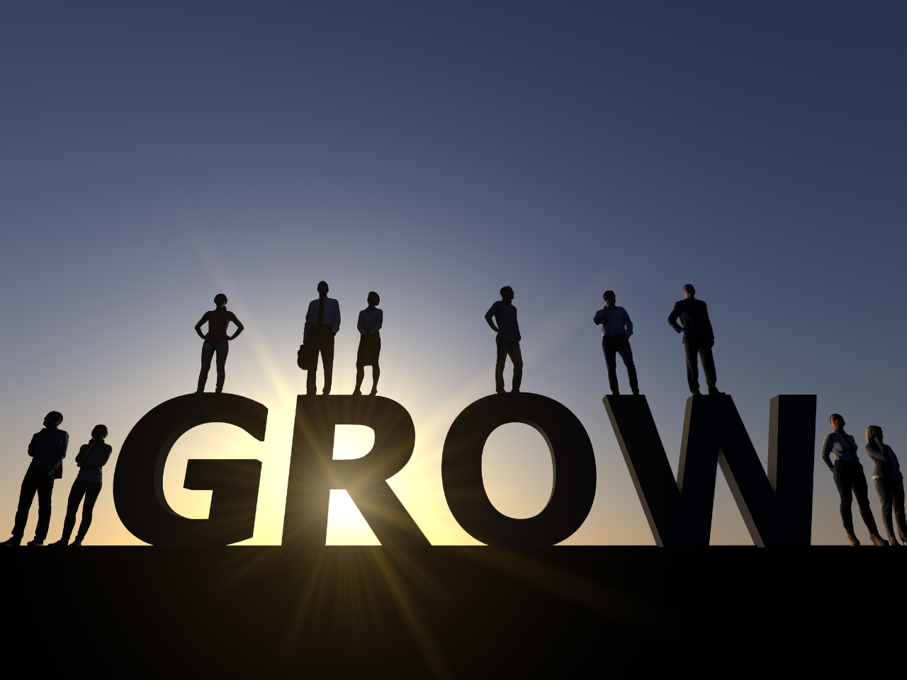 A picture of people on top of a giant block that reads as "Grow"