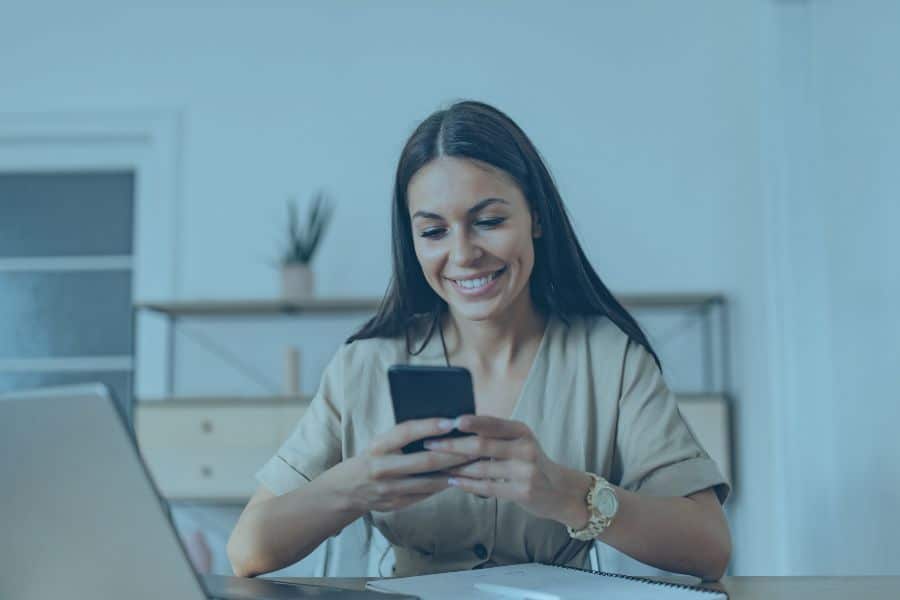 a woman smiling at her phone