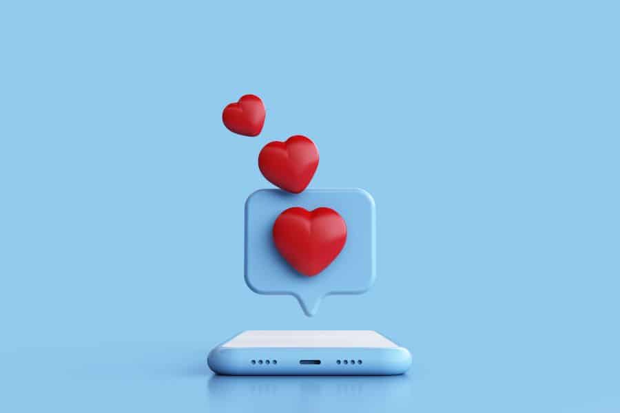 a phone with hearts floating above it